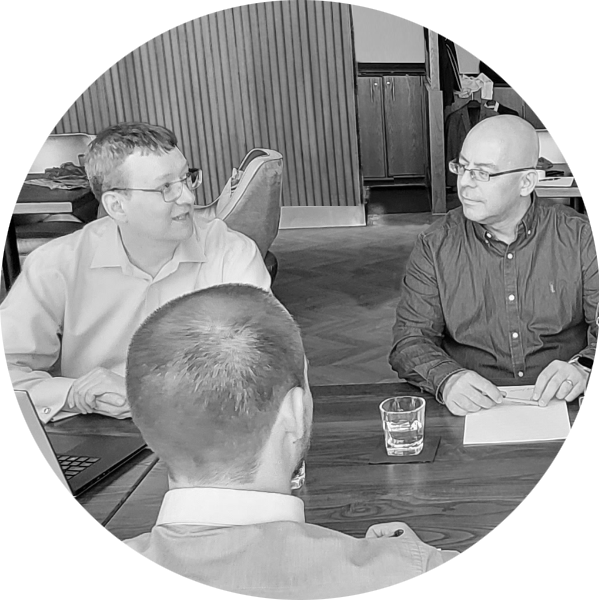Three men in a meeting talking while sat at a table