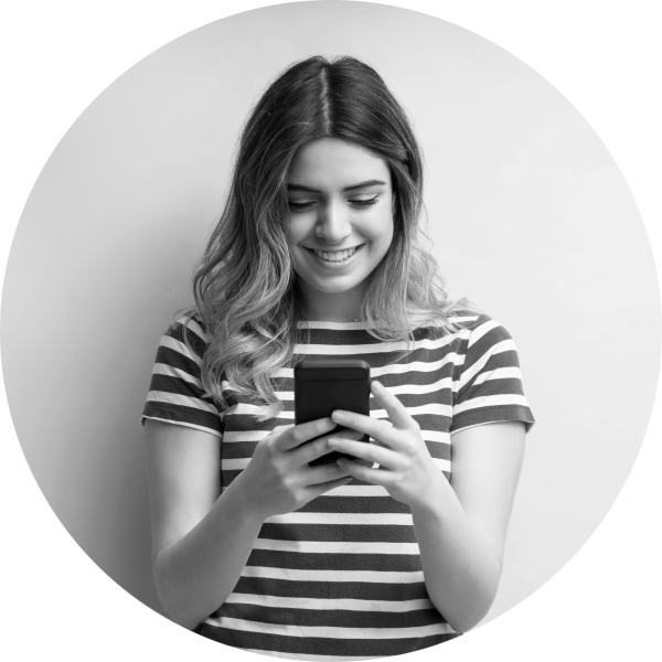 Smiling woman standing up using her smartphone