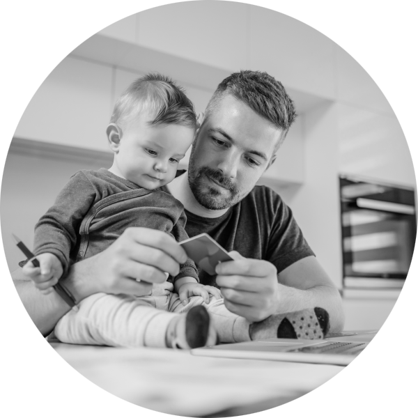 Man trying to work on his laptop while taking care of his baby