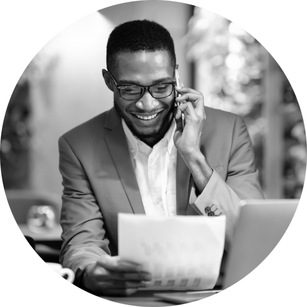 A smiling man looking at charts on a sheet of paper