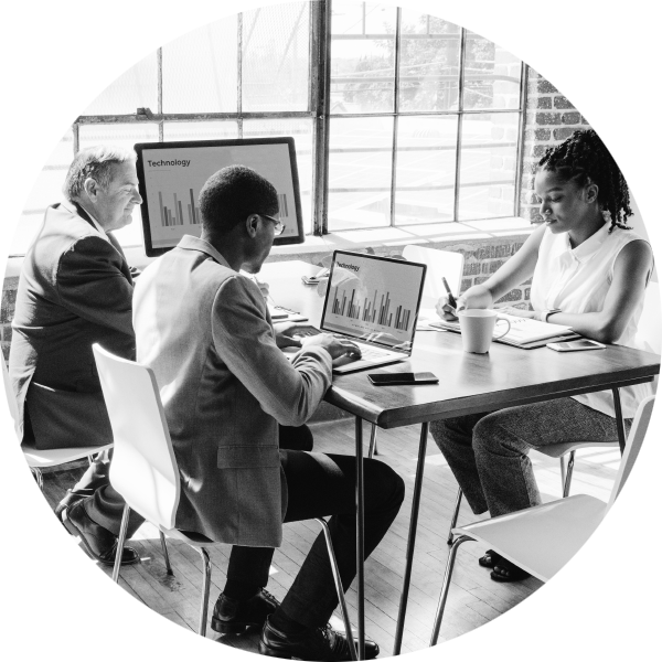 Three people sitting around a screen with one of them demonstrating a presentation.