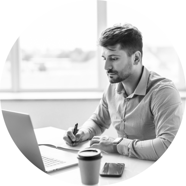 Man sitting at a laptop making a list of requirements