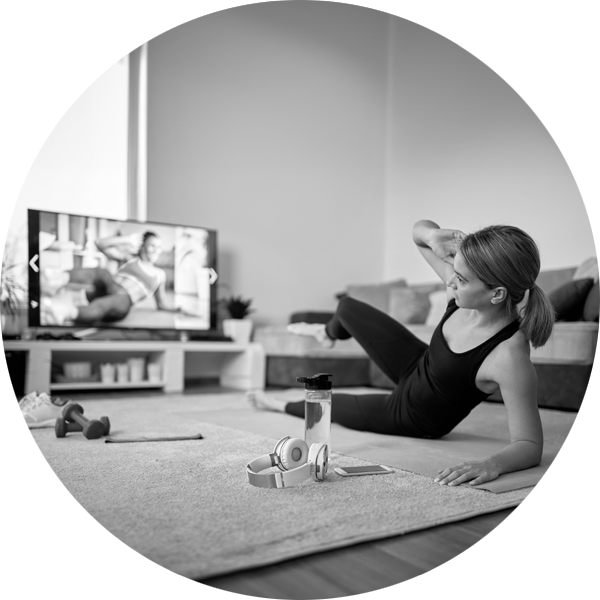 A woman taking part in an online yoga class from home
