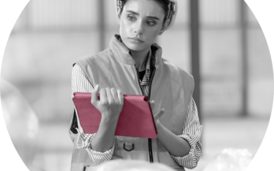 A woman performing quality control in a factory using an iPad