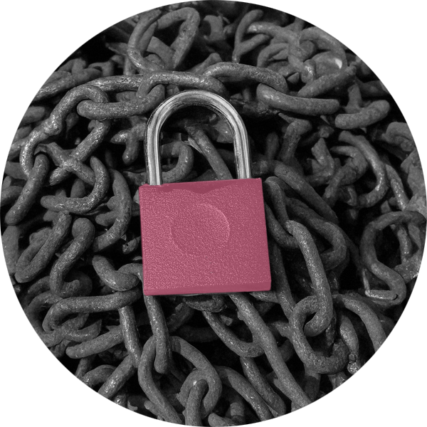 A pile of old chains with a pink padlock